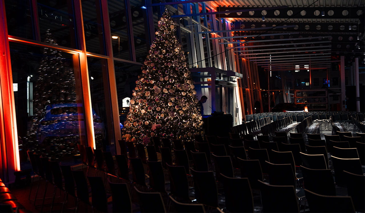 Leere Stuhlreihen mit geschmücktem Tannenbaum