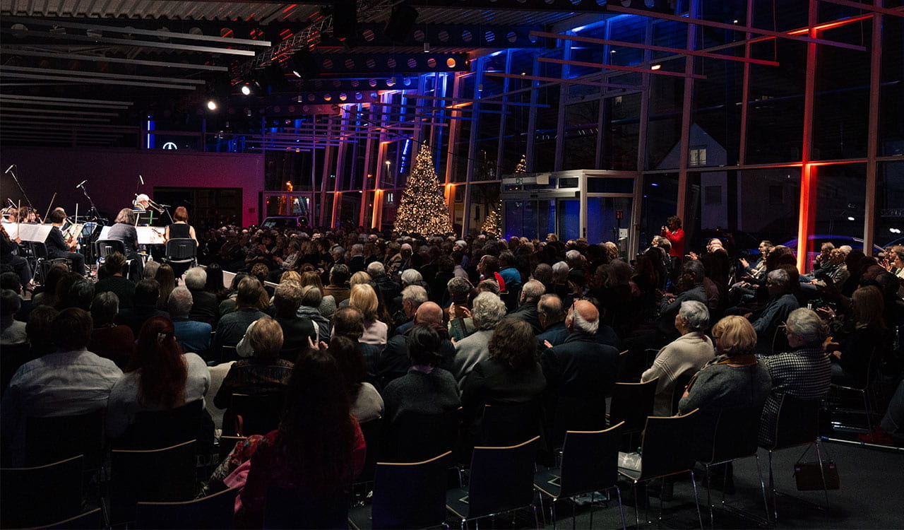 Publikum vor weihnachtlich geschmückter Kulisse