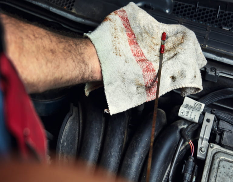  Ein Mechaniker überprüft den Ölstand eines Fahrzeugs