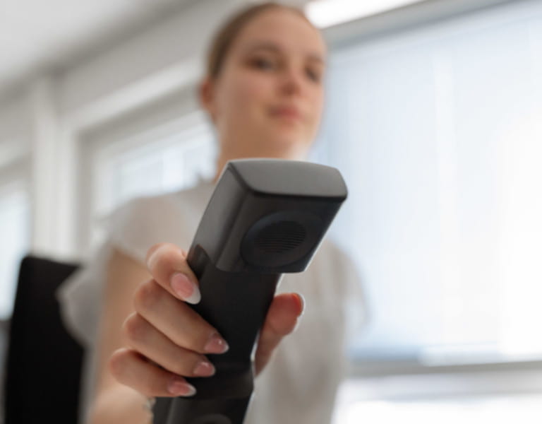 Frau hält Telefonhörer nach vorne