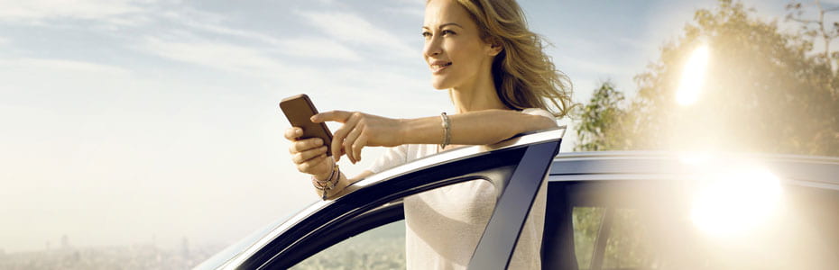 Fair Frau mit Handy am Auto