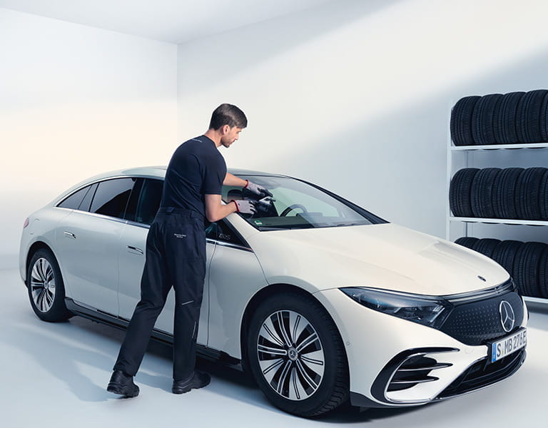 Mercedes-Benz Mitarbeiter bei der Kontrolle der Frontscheibe eines Mercedes-Benz EQS