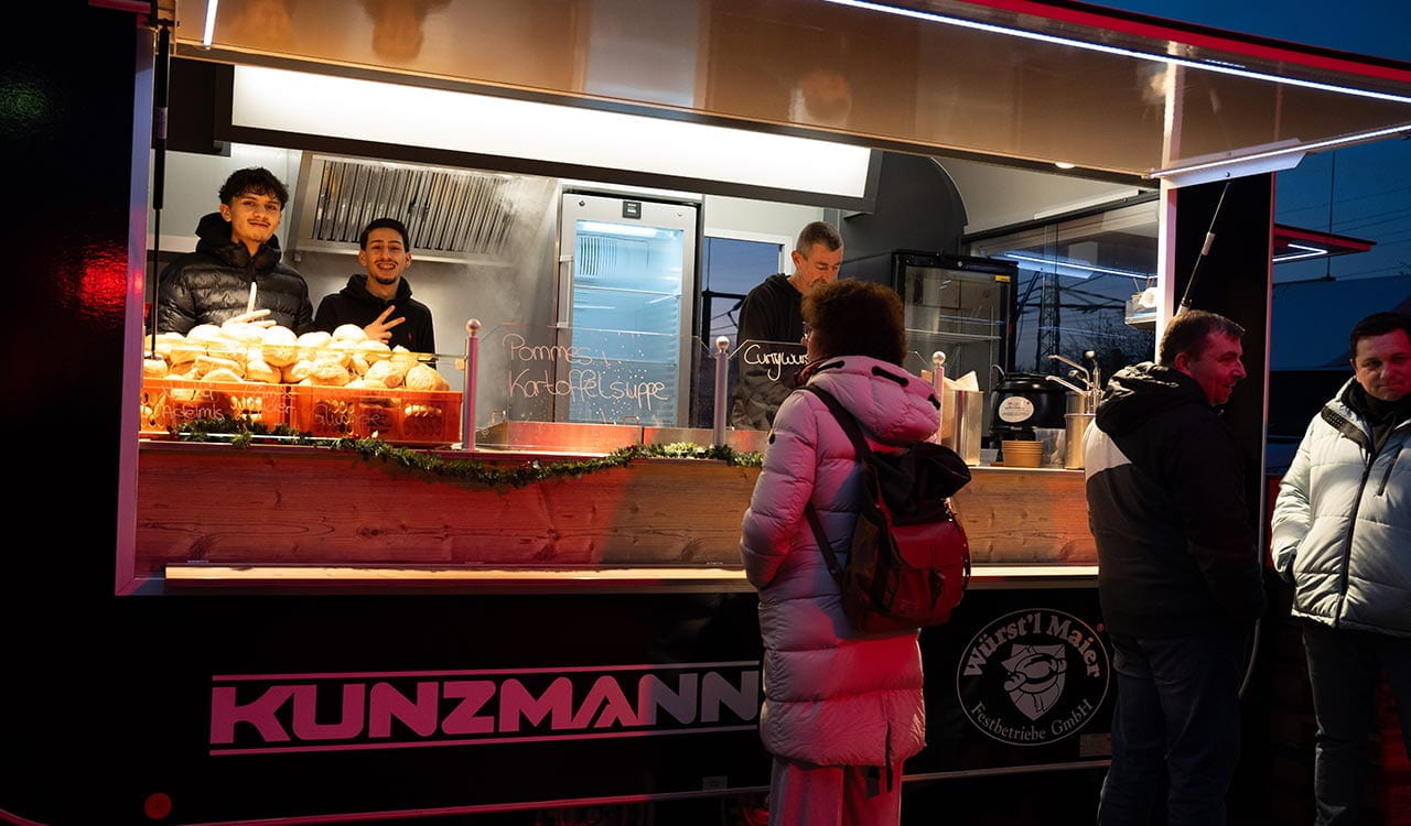 Kunden bestellen Essen am Essensstand auf dem Adventsmarkt in Stockstadt