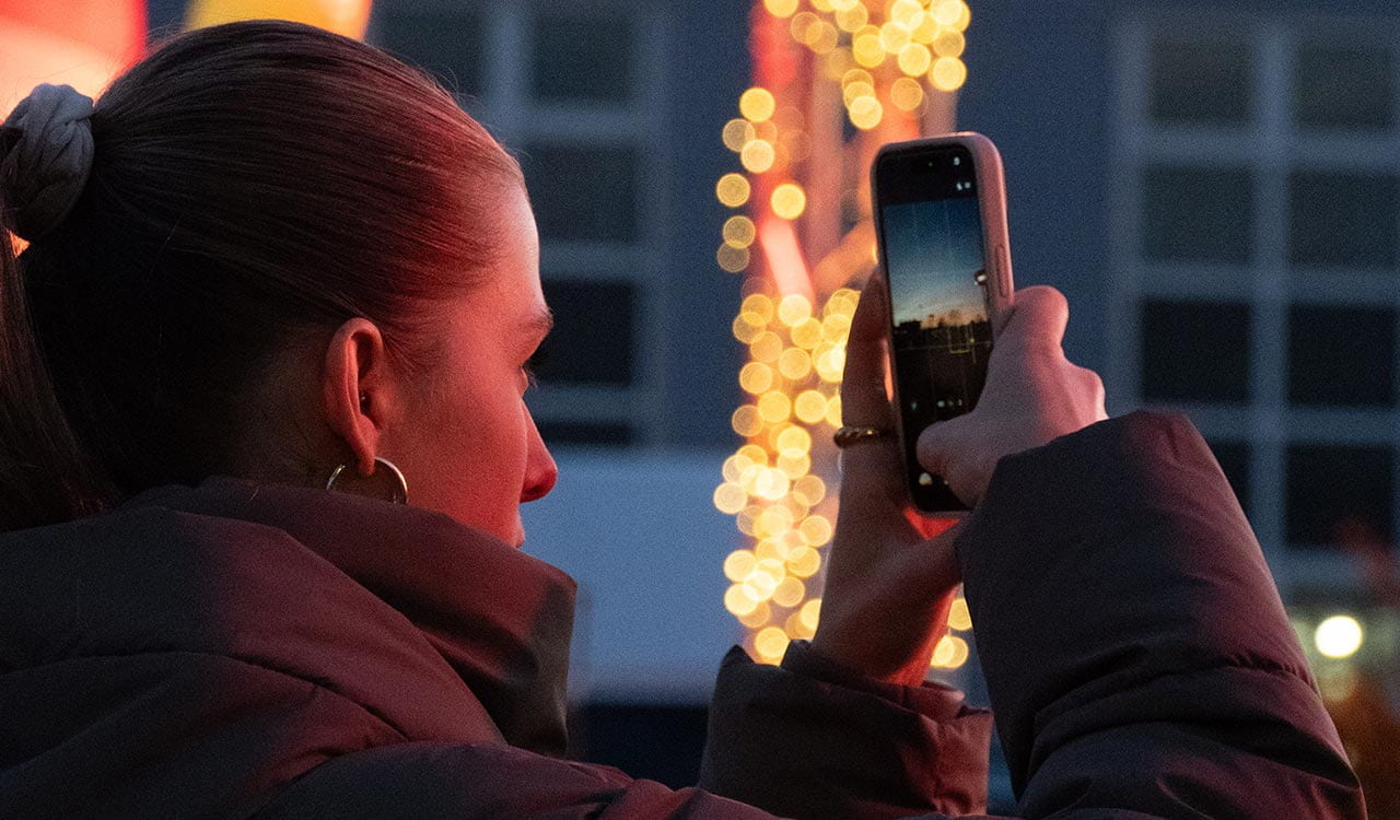 Kunde beim fotografieren des Sonnenuntergangs auf dem Kunzmann Adventsmarkt in Stockstadt