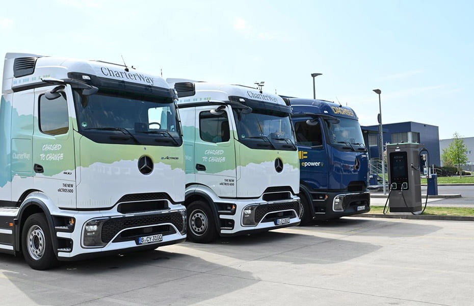drei Mercedes-Benz eActros vor einer Ladesäule