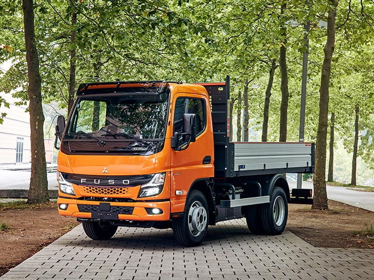 weißer FUSO eCanter mit Kipperaufbau