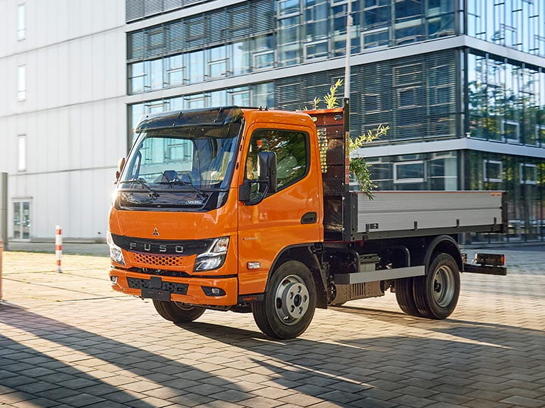weißer FUSO eCanter mit Kipperaufbau