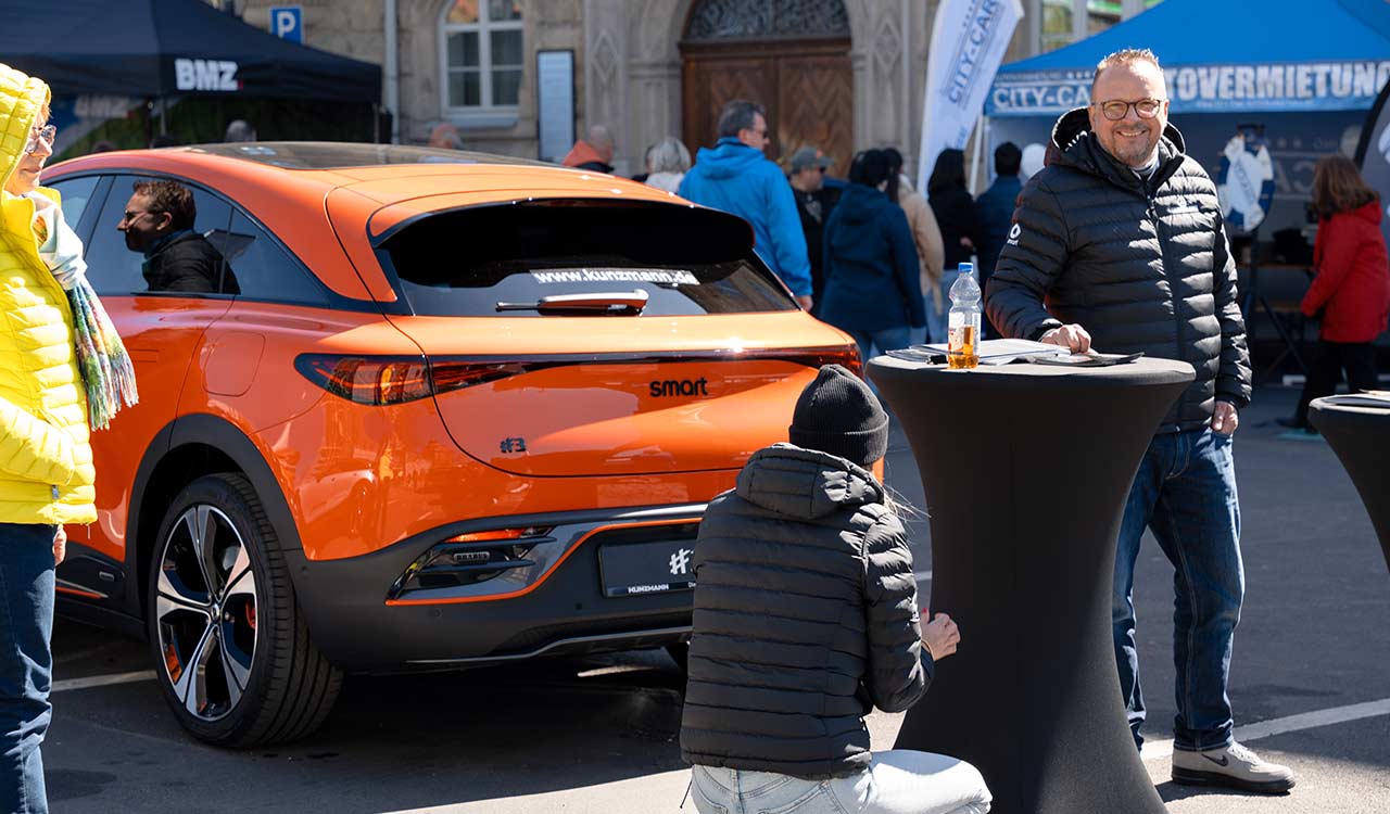 Kunzmann smart Verkäufer neben einem orangenen smart #3 auf der Mobilia 2025 in Aschaffenburg