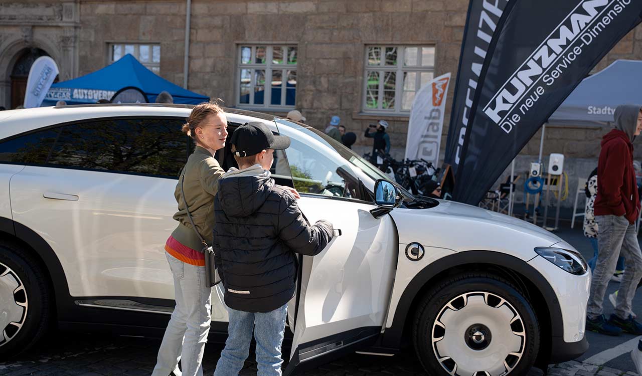 Kinder testen den weißen smart #3 auf der Mobilia in Aschaffenburg