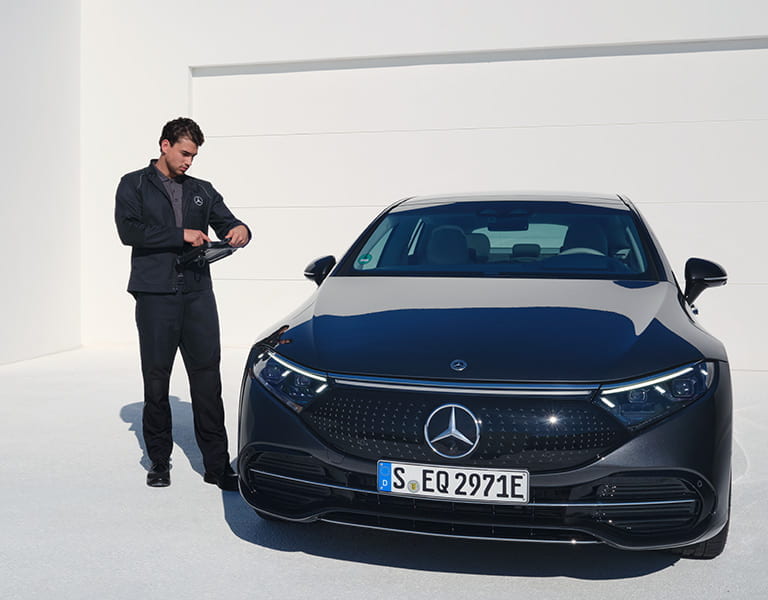 Mercedes-Benz Mechatroniker neben einem Mercedes-Benz EQE während eines Over-the-Air Update