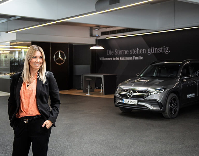 Lorraine Langer vor einem Gebrauchtwagen von Mercedes-Benz