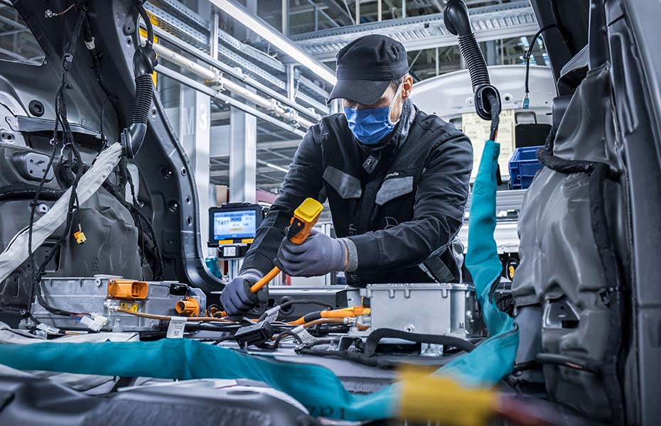 Mercedes-Benz Mechatroniker beim Arbeiten an Hochvoltkomponenten im Fahrzeug