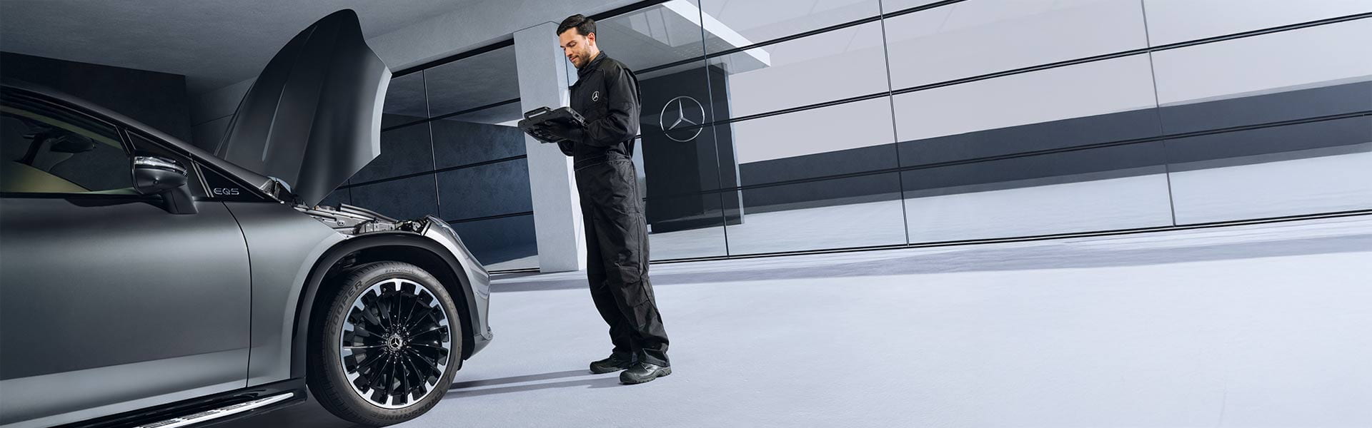Mercedes-Benz Mechatroniker beim Service neben Mercedes-Benz EQE