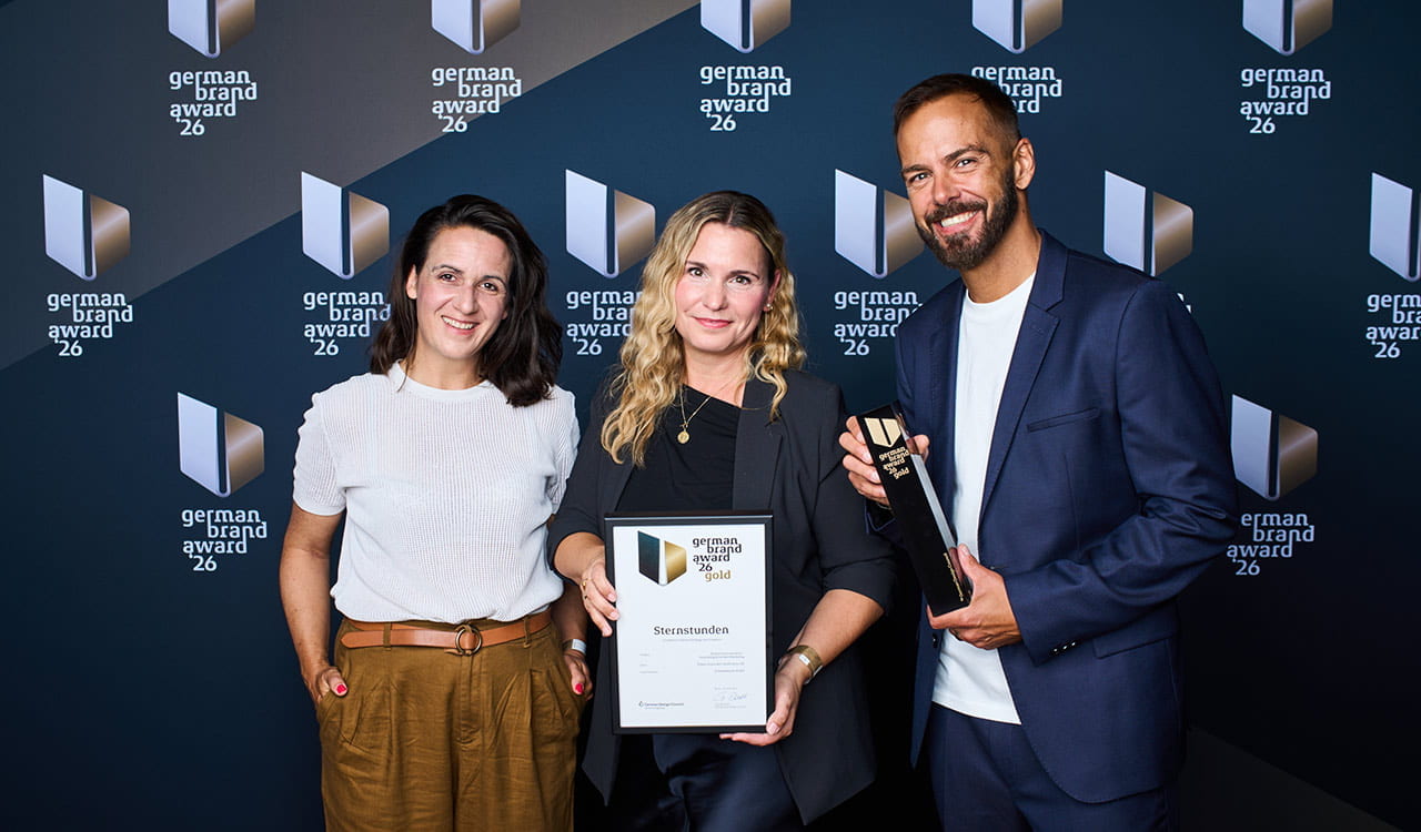Sternstunden-Team Kunzmann & SchleeGleixner mit German Brand Award vor der Gewinnerwand