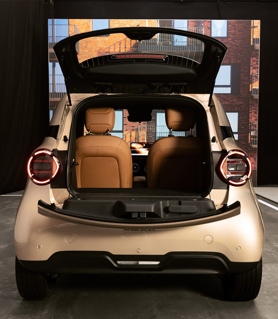 smart #2 in gold mit geöffnetem Kofferraum und Blick nach innen in der Heckansicht