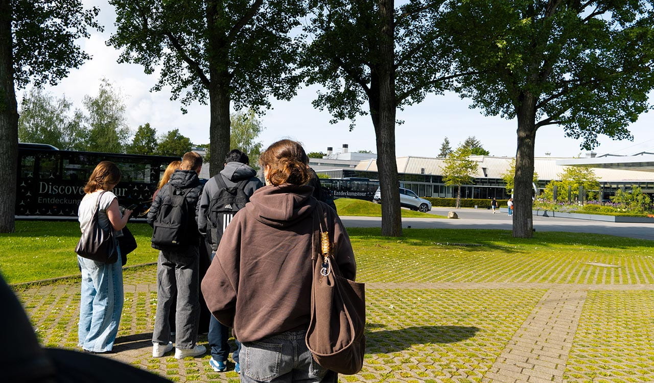 Kunzmann Azubis vor dem Mercedes-Benz Werk in Stuttgart auf einer Wiese