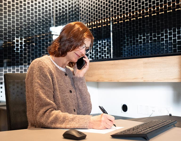 Vertrauensperson Birgit Reichert beim Telefonieren am Schreibtisch