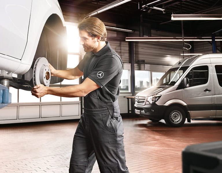 Werkstattmonteur beim Bremsenwechsel an einem Mercedes-Benz Sprinter